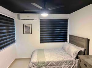 um quarto com uma cama e uma ventoinha de tecto em North Breeze Guest House em Levittown