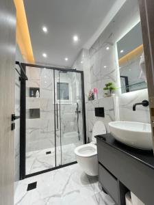 a bathroom with a shower and a toilet and a sink at 3bd jacuzzi mansion in Athens