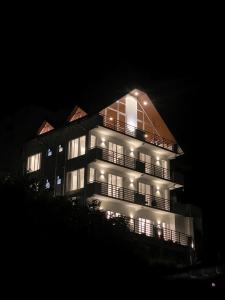 a tall building with lights on it at night at Queens Mount Glen Heights in Nuwara Eliya
