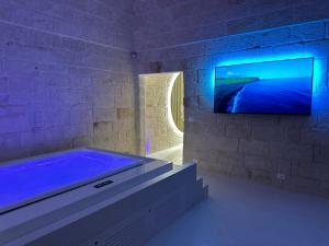 ein Badezimmer mit Badewanne und einem Fernseher an der Wand in der Unterkunft Secret Suite in Monopoli