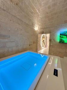 eine große Badewanne mit blauer Beleuchtung in einem Zimmer in der Unterkunft Secret Suite in Monopoli