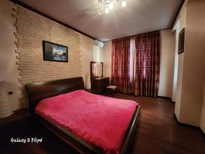 um quarto com uma cama vermelha e uma parede de tijolos em Hatai em Baku