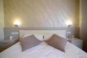 a bedroom with a white bed with two pillows at B&B Il FIORONE in Torre Canne