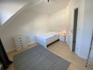 um pequeno quarto com uma cama e uma cómoda e uma cama sidx sidx em Ruhiges DG - 6 P. - urban - ÖPNV em Colônia