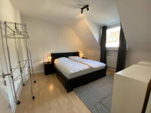 a small bedroom with a bed and a window at Ruhiges DG - 6 P. - urban - ÖPNV in Cologne