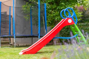 a red slide on a playground in the grass at BoRóza Vendégház in Zebegény