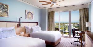 邁阿密的住宿－The Ritz Carlton Key Biscayne, Miami，酒店客房设有两张床、一张书桌和一个窗户。