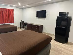 a hotel room with two beds and a television at Executive Inn in Hobbs +11 photos