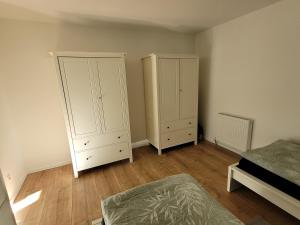 1 dormitorio con 2 armarios blancos y 1 cama en Terrassenwohnung in Siegburg, en Siegburg