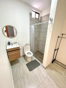 a bathroom with a shower and a toilet and a sink at Bonito Apartamento Monteria in Montería