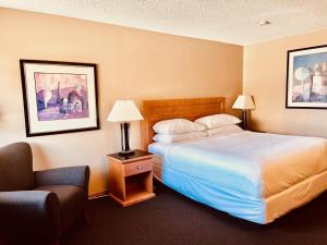 a hotel room with a bed and a chair at Royal Hotel Lloydminster in Lloydminster