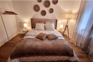 ein Schlafzimmer mit einem großen Bett mit Kissen und zwei Lampen in der Unterkunft Le 31 - Mulhouse Pfastatt in Pfastatt
