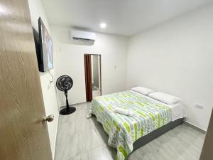 a small bedroom with a bed and a fan at Bonito Apartamento Monteria in Montería