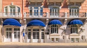 ein Gebäude mit blauen Sonnenschirmen davor in der Unterkunft H10 Duque de Loule in Lissabon