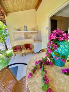 una habitación con una mesa con flores púrpuras. en Duplex Solar Água, en Pipa