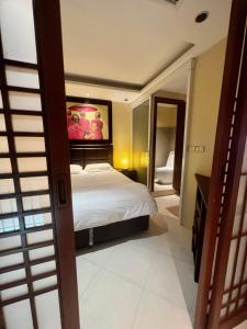 a bedroom with a bed and a painting on the wall at Luxury Apartment Kata Beach The Accenta in Kata Beach