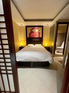 a bedroom with a bed with a painting on the wall at Luxury Apartment Kata Beach The Accenta in Kata Beach