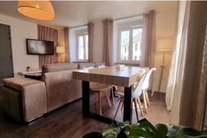 Le 31 - Mulhouse Pfastatt في Pfastatt: غرفة معيشة مع طاولة وأريكة