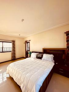 ein großes Schlafzimmer mit einem großen Bett mit weißer Bettwäsche in der Unterkunft Aspen Luxury Villa in Accra