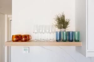 a shelf with glasses and a potted plant on it at Urban Chic Residences in Prague +22 photos