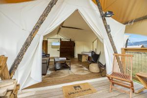 a living room with a tent with a chair at Under Canvas North Yellowstone - Paradise Valley in Livingston