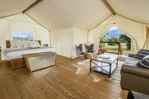 a bedroom in a tent with a bed and a couch at Under Canvas North Yellowstone - Paradise Valley in Livingston