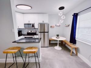 Una cocina con refrigerador de acero inoxidable y una mesa. en Holiday Park Apartments by Lowkl, en Fort Lauderdale 98 fotos más