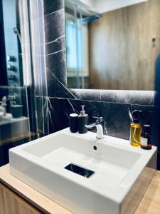 a bathroom with a white sink and a mirror at Alice, 2-4 people, renovated stylish apartment in Athens