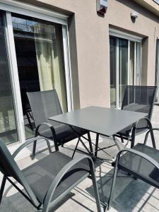 une table et des chaises assises sur une terrasse dans l'établissement Alice, 2-4 people, renovated stylish apartment, à Athènes