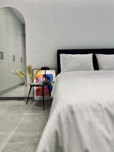 a bedroom with a white bed and a table at Alice, 2-4 people, renovated stylish apartment in Athens