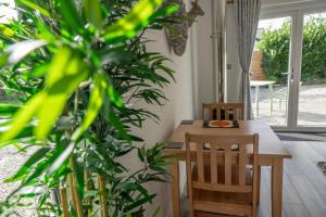 a dining room with a table and two chairs and plants at Olverstone Lodge, a beautiful Cornish lodge with wood burner & garden in St Austell