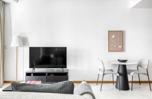 un soggiorno con divano, TV e tavolo di The Elite Enclave 2Bedroom Apartment in Singapore! a Singapore