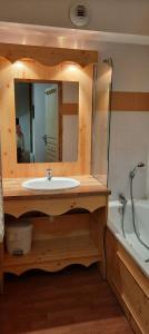 a bathroom with a sink and a mirror and a tub at Orelle Val Thorens Appartement 2 pieces 5 personnes in Orelle