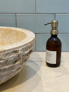 a bottle of soap on a counter next to a sink at Stylish 3 bedroom apartment in historic city centre building in Sheffield +22 photos