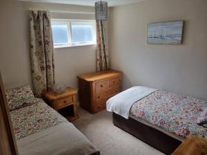 a bedroom with two beds and a window at The Apartment Benone in Castlerock