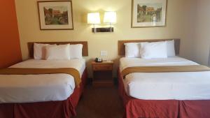 a hotel room with two beds in a room at Stadium Motel - Lubbock Medical Center in Lubbock