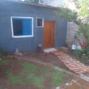 a blue house with a door and a yard at Hospedaje jabuticaba in El Soberbio