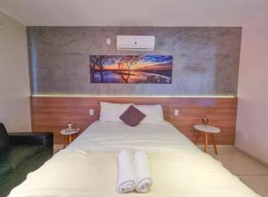 a bedroom with a bed with two towels on it at Rize Studios in Maceió