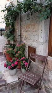 una sedia in legno seduta di fronte a un edificio con fiori di Pensión liebana a San Vicente de la Barquera