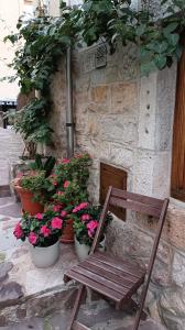 a wooden chair sitting in front of a building with flowers at Pensión liebana in San Vicente de la Barquera