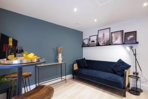 a living room with a blue couch and a table at Boutique Apartment - City Centre - Free Parking, Fast Wifi and Smart TV by Yoko Property in Rugby