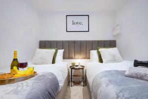 two beds in a room with a bottle of wine at Boutique Apartment - City Centre - Free Parking, Fast Wifi and Smart TV by Yoko Property in Rugby