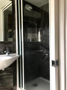 a bathroom with a shower and a sink at Onehunga Garden Tinyhouse in Auckland