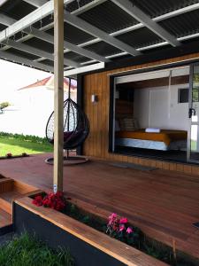 a wooden deck with a bed and a balcony at Onehunga Garden Tinyhouse in Auckland