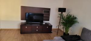 a living room with a flat screen tv on a cabinet at Incanto Apartament in Starogard Gdański