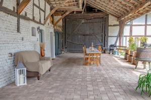 a patio with a couch and a table in a barn at Chambre indépendante n2 - Bretzel et Bergamote in Richtolsheim