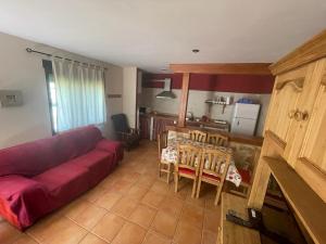 a living room with a red couch and a table at El Quejigo in Molinicos +16 photos
