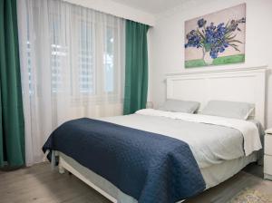 a bedroom with a large bed and a window at Escape Aparthotel in Suceava