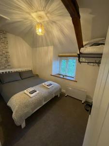 a bedroom with two beds and a window at Cosy 2 bedroom cottage in Llanuwchllyn