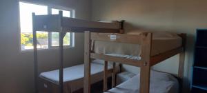 2 Etagenbetten in einem Zimmer mit Fenster in der Unterkunft La Maquinita Hostel in Mar del Plata